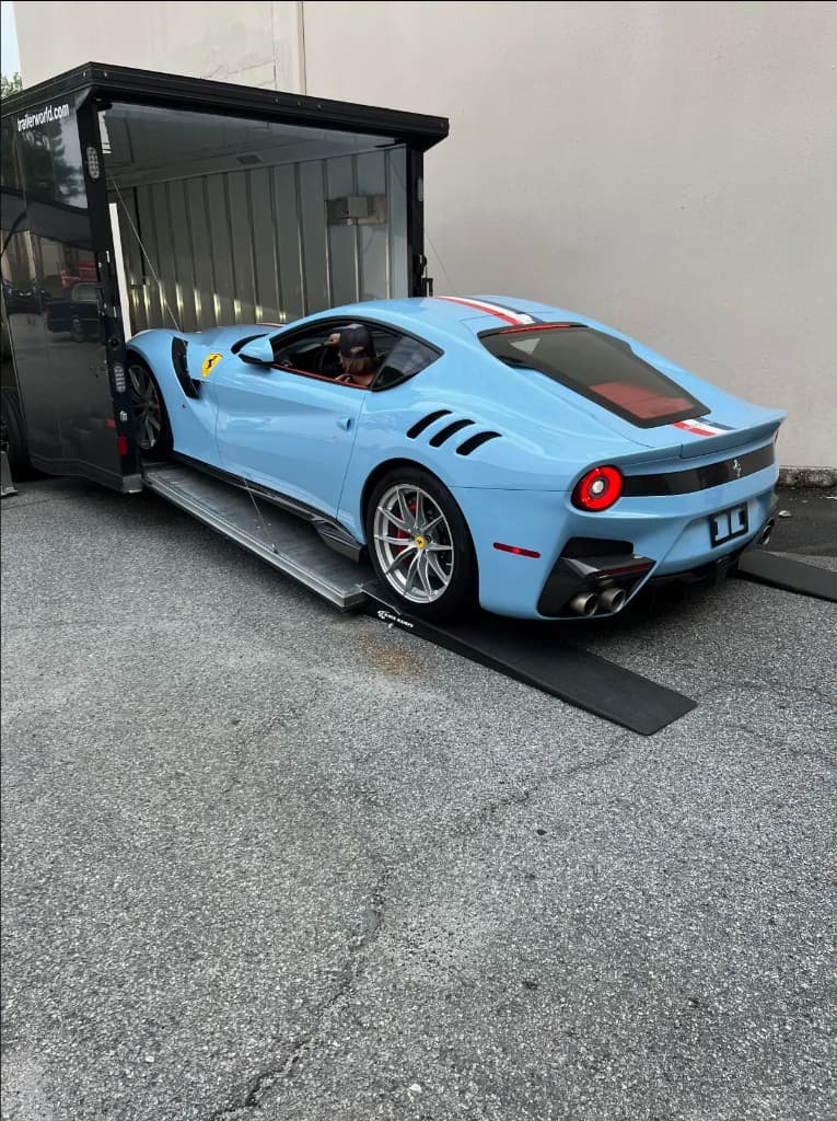 Ferrari F12tdf being unloaded from an enclosed transport trailer